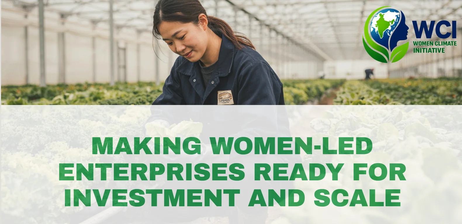 Woman working among leafy crops in a greenhouse